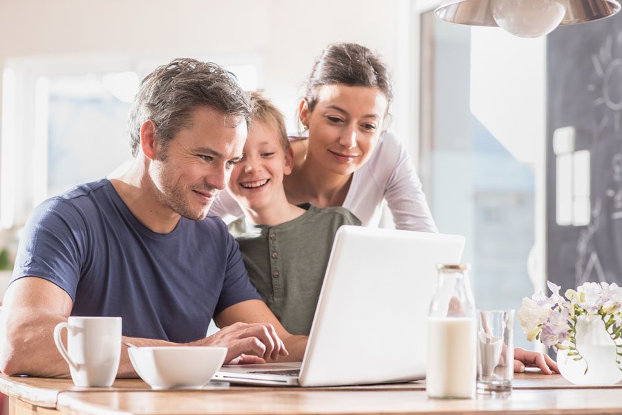 Report a Claim - Family Using the Computer at the Table